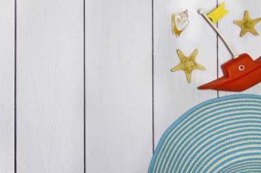 Seyahat - oyuncak tekne, şapka, çeşitli egzotik kabukları ve diğer Deniz hazineler üstten kum görünüm hafif bir ahşap zemin üzerine kavramı