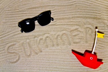 Yaz yazıtlı berrak deniz kumu, metin ve üst görünüm için alan. Güneş gözlüğü ile yaz tatili arka plan