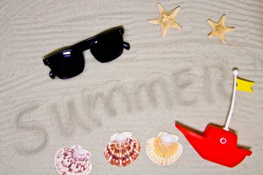 Yaz yazıtlı berrak deniz kumu, metin ve üst görünüm için alan. Deniz kabukları ve güneş gözlüğü ile yaz tatili arka plan