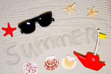 Yaz yazıtlı berrak deniz kumu, metin ve üst görünüm için alan. Deniz kabukları ve güneş gözlüğü ile yaz tatili arka plan