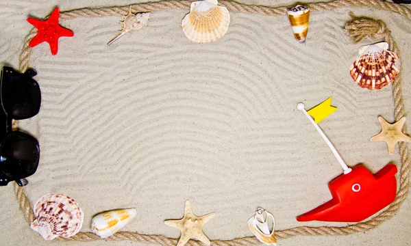 Морські черепашки та прикраси мотузки на піщаному фоні з сонцезахисними окулярами — стокове фото