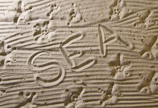 A palavra "mar" é escrita à mão na areia da praia . — Fotografia de Stock