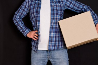 Genç paket teslimatçısı elinde bir karton kutu tutuyor..