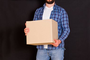 Genç paket teslimatçısı elinde bir karton kutu tutuyor..