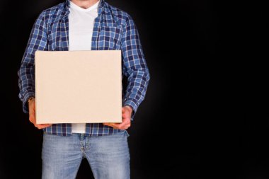 Genç paket teslimatçısı elinde bir karton kutu tutuyor..