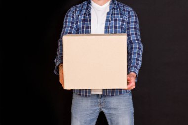 Genç paket teslimatçısı elinde bir karton kutu tutuyor..