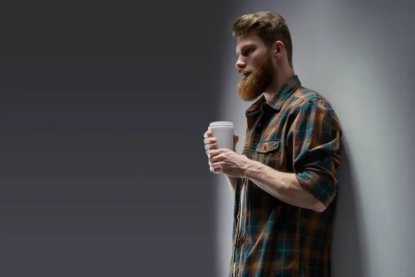 Hombre barbudo confiado sosteniendo una taza de café —  Fotos de Stock