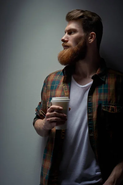 Üstünde belgili tanımlık gitmek sabah kahve içme genç sakallı adam yan görünüm — Stok fotoğraf
