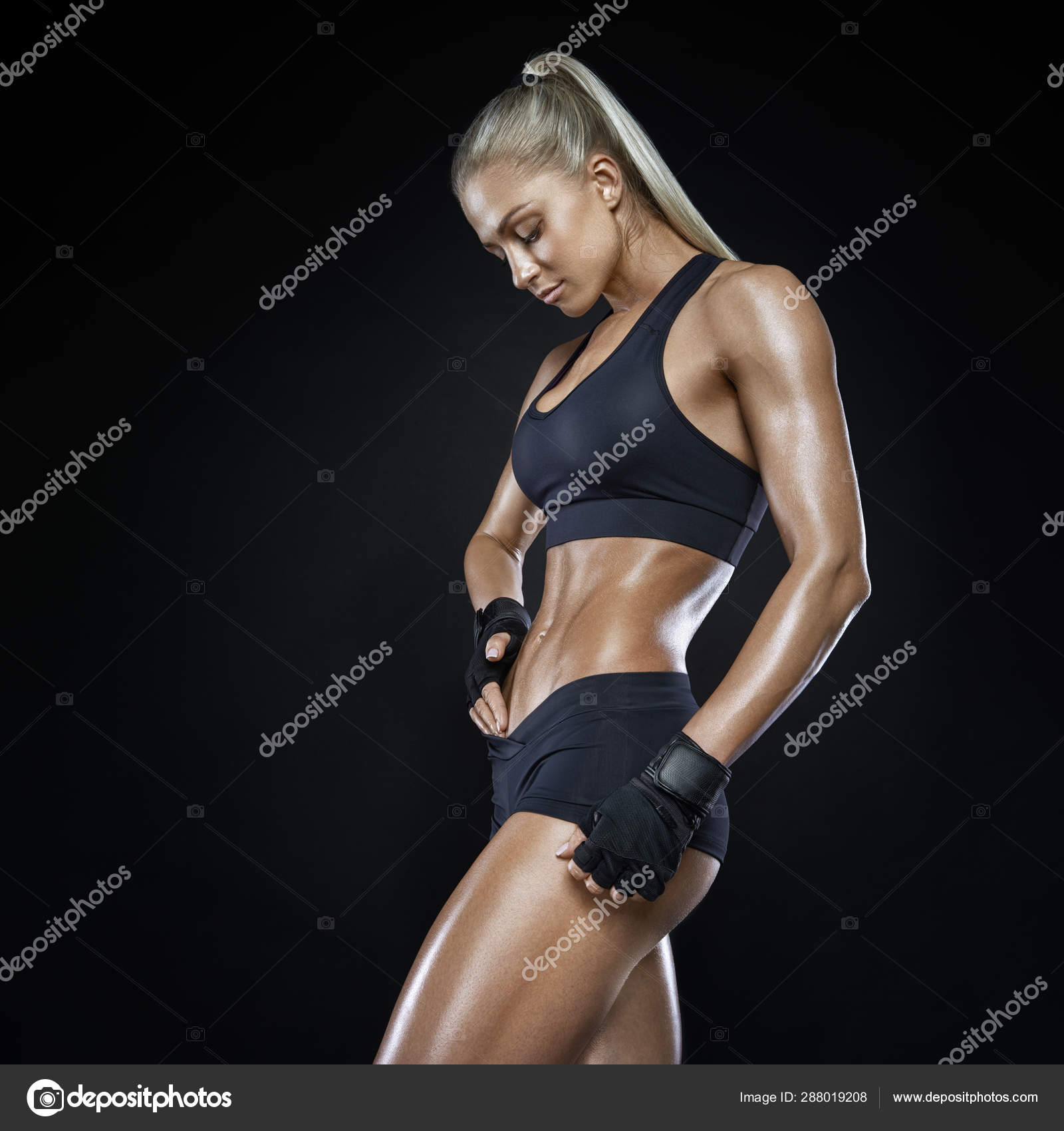 Fitness athletic young woman showing her well trained body, six pack,  perfect abs, shoulders, biceps, triceps and chest, deltoid muscle Stock  Photo