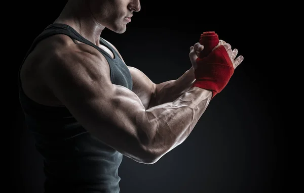 Strong man wrap hands on black background — Stock Photo, Image