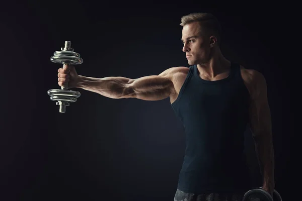 Handsome power athletic man in training pumping up muscles holdi — Stock Photo, Image