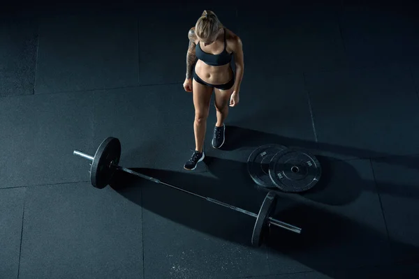 Meisje met een lange halter in de sportschool — Stockfoto