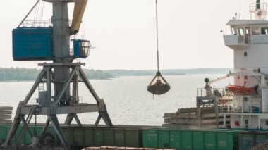 Yük limanda çalışmak. Bağlantı noktası deniz vinç Körfezi'nin arka planda bir kuru yük gemisi için demiryolu araçları kömür kaldırır