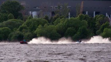 Bu sularda Aquabikes hafta sonu. St Petersburg, Rusya, 2 Temmuz 2016. Yeni futbol stadyumu. İki sporcular üzerinde hızlı bir arka plan ağaç üzerinde hareket aquabikes
