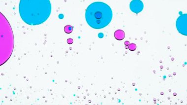 Maddelerden karıştırma ilaç. Parlak renkli baloncuklar yavaşça beyaz arka plan taşımak ve kendi boyut ve şeklini değiştirmek