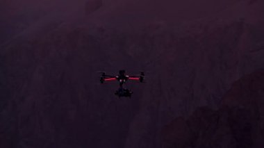 Güçlü quadrocopter kanyon üzerinde günbatımında kıvrılmış. Ağır çekim 240 fps hızında