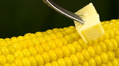 Bir parça tereyağı bir çatalı yavaş yavaş sinirli sıcak Mısır, iştah açıcı bir erime iz bırakarak yüzeyi boyunca hareket eder