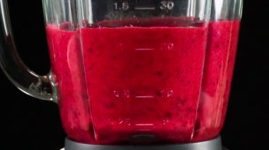 Öğütülmüş kızılcık yavaş yavaş içinde çalışan bir blender closeup döndürmek