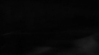 Yavaş yavaş siyah bir arka plan üzerinde yüzen hayalet beyaz sis artıkları. 240 fps hızında hareket