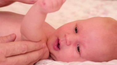 1 aylık bebek onun arkasında yatan. Yavaşça okşayarak el