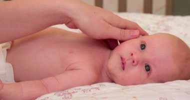 1 aylık bebek onun arkasında yatan. Yavaşça okşayarak el