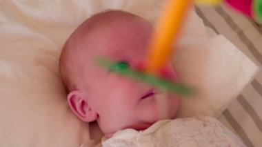 2 aylık bebek oyun parkı içinde olduğunu. Kamera ve onun arasında oyuncak atlıkarınca döner. Bir ninni yumuşak melodi oynarken