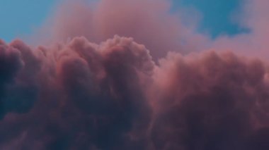 Bulutlar kaynayan günbatımı pişmiş toprak renk kaplı. Uzaylı atmosfer göstermektedir. Zaman atlamalı