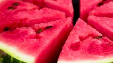 Üçgen karpuz dilimlerini yavaş yavaş kamera önünde döndürme