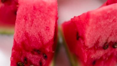 Video Loops. Triangular pieces of watermelon are on a rotating fruit plate. Camera looks sideways down
