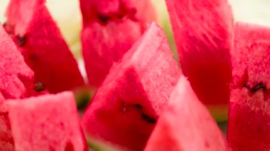 Video Loops. Triangular pieces of watermelon are on a rotating fruit plate. Camera looks sideways down