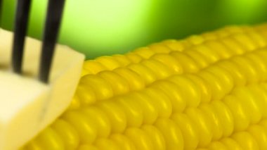 Bir parça tereyağı bir çatalı yavaş yavaş sinirli sıcak Mısır, iştah açıcı bir erime iz bırakarak yüzeyi boyunca hareket eder