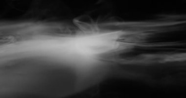Ağır beyaz duman yavaşça siyah yüzeye yayılır ve yavaş yavaş çözünür.