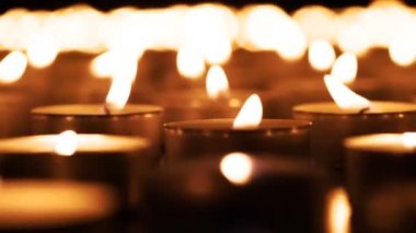 Koyu granit bir yüzey üzerinde yanan küçük mumlar büyük bir alan. Hava yavaşça ışık sallıyor. 240fps hızında çekildi