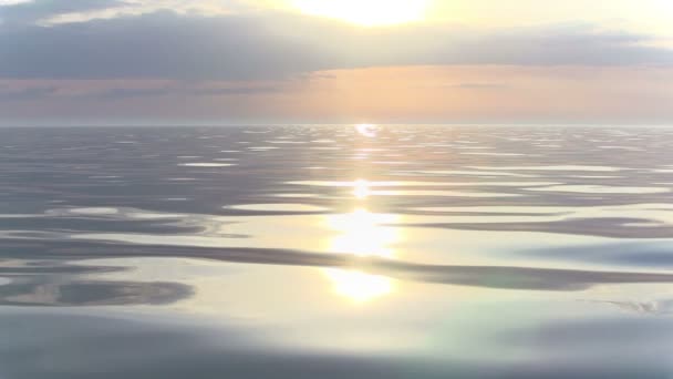 Le soleil levant sur l'horizon rose éclaire doucement la mer calme. Mouvement lent à 240 ips 