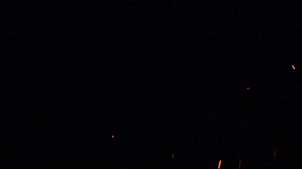 明るい赤熱の火花は 黒の背景上でランダムに 異なる速度で移動します 240Fpsの速度で撮影 — ストック動画