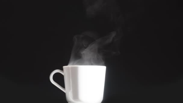 白杯加热饮 明亮的白色杯子 热气在黑色的背景上缓缓升起 — 图库视频影像