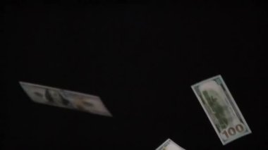 100 Dolarlık banknotlar yükseldi. Döngü. Parasal değerler 100 dolar ve yavaşça siyah arkaplan üzerine düşüyor. 240 fps hızla çekiliyor.
