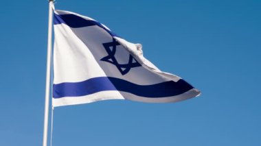 İsrail bayrağı rüzgarı dalgalandırıyor. Büyük Eyalet Bayrağı güneş tarafından aydınlatılır ve mavi gökyüzüne karşı destansı bir şekilde dalgalanır. Slow Motion 240 fps