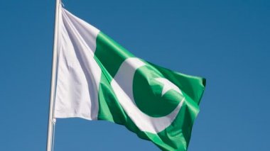Pakistan Bayrağı Rüzgarı Dalgalandırıyor. Büyük Eyalet Bayrağı güneş tarafından aydınlatılır ve mavi gökyüzüne karşı destansı bir şekilde dalgalanır. Slow Motion 240 fps