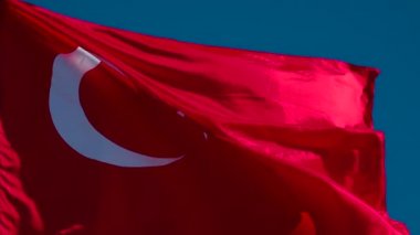 Türk Bayrağı Rüzgarı Dalgalandırıyor. Büyük Eyalet Bayrağı güneş tarafından aydınlatılır ve mavi gökyüzüne karşı destansı bir şekilde dalgalanır. Slow Motion 240 fps