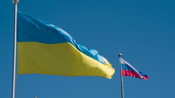 ウクライナとロシアの国旗 青い空に向かって飛んでいる矛盾する状態の2つのフラグ スローモーション240 Fps — ストック動画
