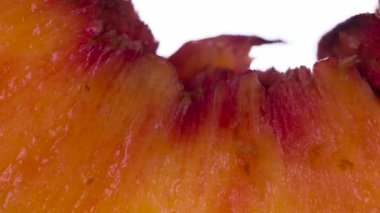Kokulu şeftali dilimini ez. Kokulu olgun şeftali dilimleri sıkıştırılır ve parlak beyaz bir arka planda ezilerek sulu bir Pulp ve kabuk akışı oluşturulur. 120fps 'te atış