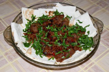 Soğan ve biber ile kızarmış et Pide üzerine koydu taze otlar ile serpilir.