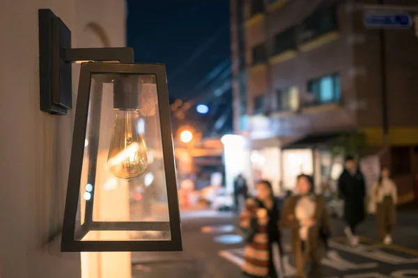 vintage street lamp with incandescent lamp in the street.Beautiful street lamp in the evening against the background of walking people. lamp on a busy street