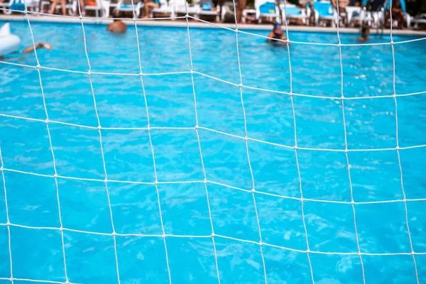 White mesh for water polo close-up on a background of a pool for relaxation. The net of water polo gates against the background of clear water in the pool.