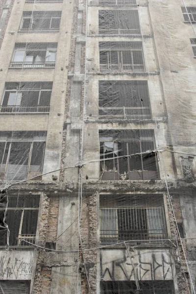 Building under renovation covered with plastic protection and a protection wall