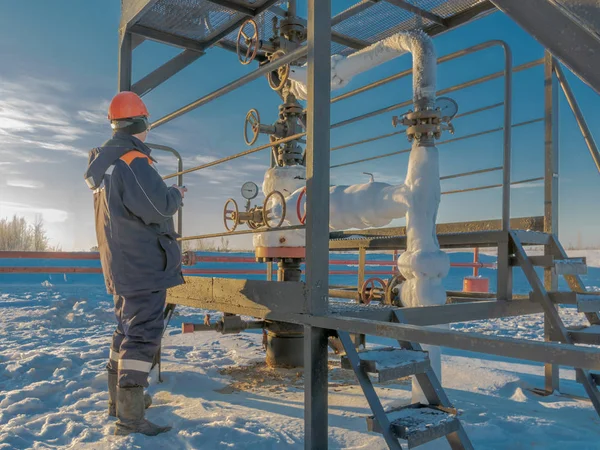 Işleç kışın Kuzey petrol alanında bir petrol kuyusu Hizmetleri. Petrol üretimi için donatım buzla kaplıdır.
