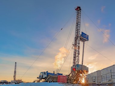 Bir petrol ve gaz alanında bir sondaj teçhizat ile derin bir kuyu sondaj. Alanın Kuzey Kutup Dairesi ötesinde Far North yer alır. Kutup günün güzel dramatik gökyüzü.