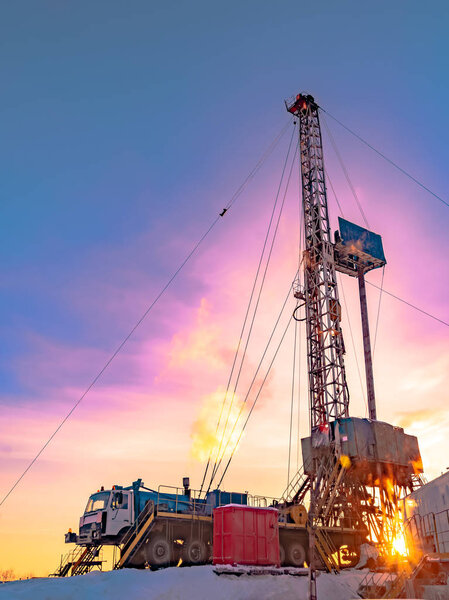 Drilling a deep well with a drilling rig in an oil and gas field. The field is located in the Far North beyond the Arctic Circle. The shooting took place in the winter on a polar day. The sun symbolizes the energy of the Earth.