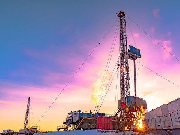 Drilling a deep well with a drilling rig in an oil and gas field. The field is located in the Far North beyond the Arctic Circle. The shooting took place in the winter on a polar day. The sun symbolizes the energy of the Earth.